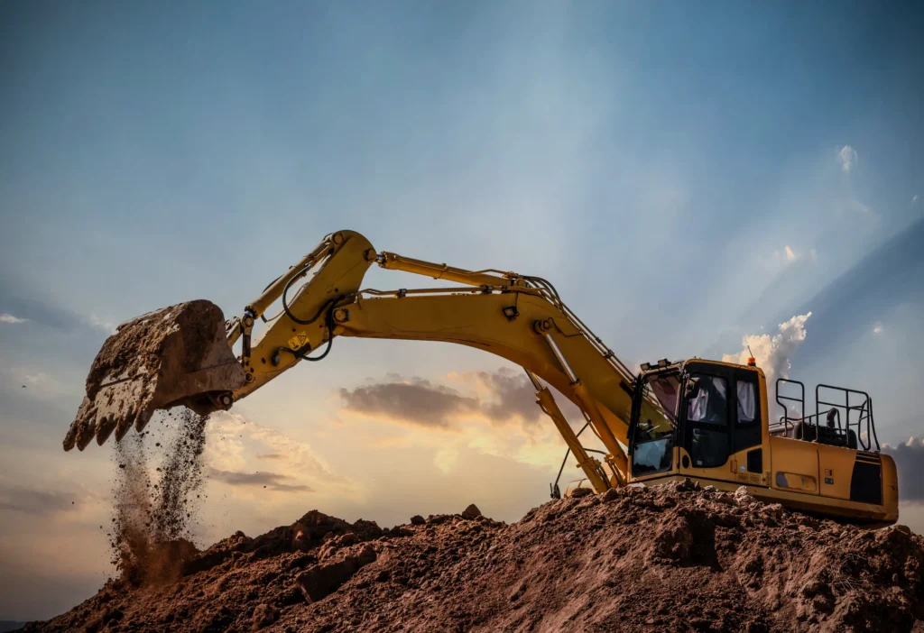 A Excavator at work against a cloudy sky, moving earth on a mound in Galva, IL.